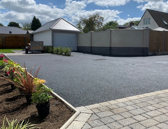 The front of a house with a new tarmac driveway.